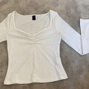 Söt u-ringad topp med spets kant - Jättefin vit långärmad med lite spet i u-ringningen, tyvärr förlusten för mig men i väldigt fint skick!