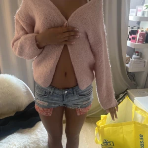 Ljusrosa stickad kofta - Superfin ljusrosa stickad kofta i underbart material, perfekt för en sen sommarkväll och kan stylas på många olika sett! Inga defekter. Koftan har en oversized fit som passar både S/M/L beroende på hur man vill att den ska sitta!