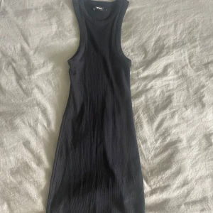 Svart ribbad kort klänning Bik Bok - Snygg svart ribbad kortklänning från Bik Bok. Ärmlös modell med rund halsringning och tight passform🖤