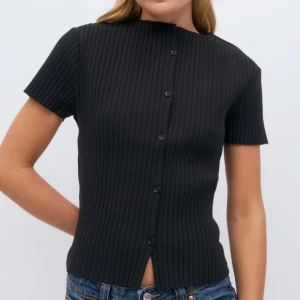 Svart ribbad blus från Gina Tricot - Svart ribbad blus från Gina Tricot med korta ärmar och knappar hela vägen framtill. Toppen är helt oanvänd med prislapp kvar. 🥳✨✨