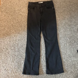 Svarta bootcut jeans från JDY - Svarta jeans från JDY med klassisk femficksdesign och bootcut-ben. Snygg passform med lite utsvängda ben och midja i normalhöjd. Perfekta till sneakers eller boots för en chill och trendig look.