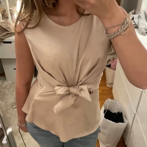 Beige topp med knyt - söt beige topp med knyt från zara i storlek S. helt ok skick. köp flera plagg i bundles för ett billigare pris!❤️