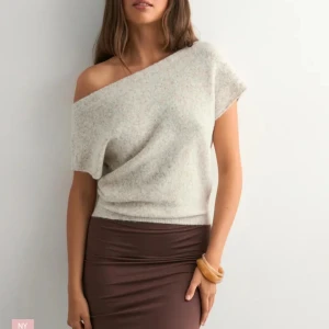 Ljusbeige offshoulder stickad topp - Supermjuk ljusbeige stickad topp med offshoulder-design och kort ärm. Slutsåld på nellys hemsida! Har aldrig använt tröjan. Ny med prislapp.