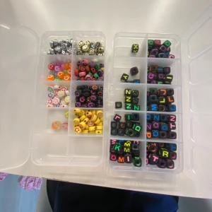 Pärlkit med smileys och bokstäver - Säljer ett pärlkit med färgglada smiley-pärlor i olika färger och metallic, samt svarta kubpärlor med neonfärgade bokstäver. Perfekt för att göra egna armband, halsband eller örhängen!🫶🏻 en box för 30kr båda för 50kr🤍🎀