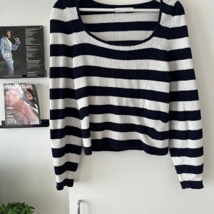 Randig stickad tröja från MNG - Säljer en ribbstickad tröja från MNG i marinblått och vitt. Tröjan har breda horisontella ränder, rundad djup ringning och långa ärmar. Perfekt för dig som gillar en chill och klassisk look.