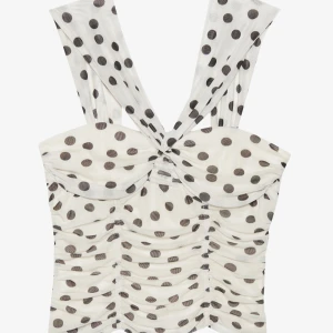 Prickig vit linnetopp med twist - Supersöt vit top med svarta prickar och breda axelband. Toppen har twistad detalj framtill och snygg rynkning längs hela plagget för en cool och trendig look. Perfekt att styla med både jeans och kjol för en lekfull vibe. Har använts 2 gånger!💘