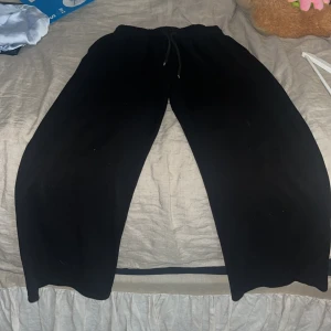 Svarta mjukisbyxor från Lager 157 - Svarta mjukisbyxor från Lager 157, modell ALMA. Byxorna har breda ben, resår i midjan och snörning för extra komfort. Perfekta för chill dagar eller när du vill ha en avslappnad stil. Tillverkade i mjukt material som känns skönt mot huden.