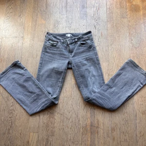 Grå jeans från Gina Tricot - Snygga grå jeans från Gina Tricot med bootcut och klassisk femficksdesign. Jeansen har bakfickor med lock och knapp, samt en cool tvättad look. Perfekta för dig som gillar en avslappnad men stilren vibe. För frågor eller mer bilder skicka pm💕
