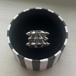 Silvrig ring med nitar från Edblad - Silvrig nitring från Edblad i toppen skick, inga missfärgningar eller slitage. Storlek 16,8 och nypris är 400kr. Går ner till 150 vid direkt köp. 