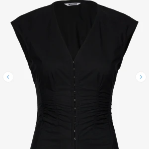 Weekday topp - Snygg svart topp från Weekday med v-ringning och markerad midja. . Perfekt för dig som gillar stilrena och moderna plagg. Endast använd en gång. NYPRIS = 489