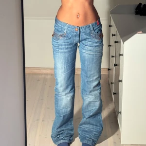 Low bootcut jeans med röda detaljer  - Jättesnygga y2k jeans med röda detaljer! Storlek 38 och i mycket bra skick🫶 Köpt på plock men var tyvärr för små 🥰