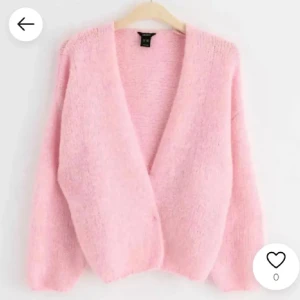 Ljusrosa fluffig kofta från Monki - Supermysig ljusrosa kofta från Monki med fluffig känsla och djup v-ringning. Koftan har långärmade ärmar och en loose passform som gör den extra chill. Perfekt att slänga på sig när du vill ha en soft och söt look.