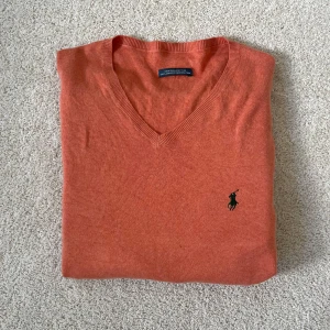 Orange v-ringad tröja från Polo Ralph Lauren - Ralph lauren stickad tröja | Skick – 8/10 | Size – L | Hör av dig vid minsta fråga eller fundering!! Lägg märke till de jätte små fläckarna på framsida se bild!