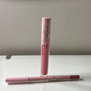 Kylie Jenner läppkit Snow Way Bae - Säljer ett Kylie Jenner läppkit i färgen Snow Way Bae. Kitet innehåller ett flytande läppstift och en matchande läppenna i en mjuk, rosabrun nyans. Båda har snygg rosa förpackning med silvriga detaljer och klassisk droppdesign. Perfekt för att skapa fylliga, definierade läppar.