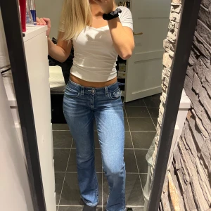 Blå bootcut jeans med broderade fickor - Snygga blå jeans med bootcut passform och låg midja, som aldrig kommit till användning.