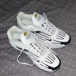 Nike Air Max Plus vita och svarta - Nike Air Max Plus sneakers i vitt med svarta detaljer och coola grafiska linjer. Skorna har synlig Air Max-dämpning, snörning och Tn-logga på plösen och sulan. Ovandelen är i syntet och mesh för en sportig vibe. Perfekta för dig som vill sticka ut med din sneakerstil.
