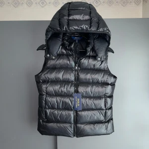 NY Ralph Lauren Väst - Mycket fint skick, inga defekter, ralph lauren prislapp medföljer. Storlek XS passar dig som är mellan 165-175cm. Nypris ca 5000kr. Modellen är 185 cm, 79 kg(sitter ca 10-15cm för kort. Passar bra nu till sen sommar/höst. Skriv för mer information!🤝