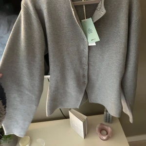 Grå tröja från gina  - Skit snygg trendig tröja!! Ny med prislapp då jag aldrig använt den pga av förstor. Syns dåligt på bilderna men den går in skit snyggt i midjan😍😍 Finns inte att få tag i🙈