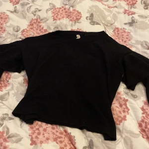 Svart croppad stickad tröja - En svart croppad stickad tröja. Som e tajtare i midjan och vidare i ärmarna 