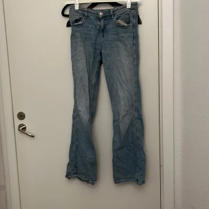 Ljusblå jeans från Gina Tricot - Säljer ett par ljusblå jeans från Gina Tricot. De har en klassisk femficksdesign och är tillverkade i denim. Perfekta för en avslappnad stil.