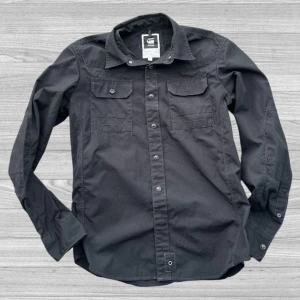 G-Star RAW overshirt - Snygg svart skjorta från G-Star RAW med långa ärmar och knappar framtill. Skjortan har två bröstfickor med knappstängning och en klassisk krage. Perfekt för en stilren look.