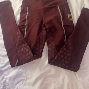 Vinröda leggings från Maya Delorez - Snygga vinröda leggings från Maya Delorez med hög midja och mönstrade detaljer. Tillverkade i ett mjukt och bekvämt material.