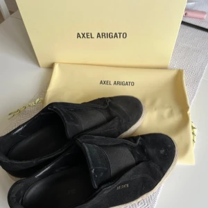 Svarta Axel Arigato Clean 360 Laceless - Snygga svarta Axel Arigato Clean 360 Laceless sneakers i skinn. Dessa stilrena sneakers har en elastisk ovandel för enkel på- och avtagning. Perfekta för en minimalistisk look.