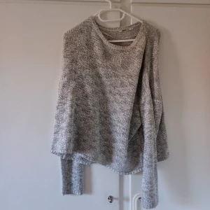 Grå stickad tröja från Gina Tricot - Säljer en mysig grå stickad tröja från Gina Tricot. Tröjan har en rund halsringning och långa ärmar, perfekt för kyligare dagar. Den är i en melerad grå färg som passar till det mesta. Perfekt för en avslappnad stil.