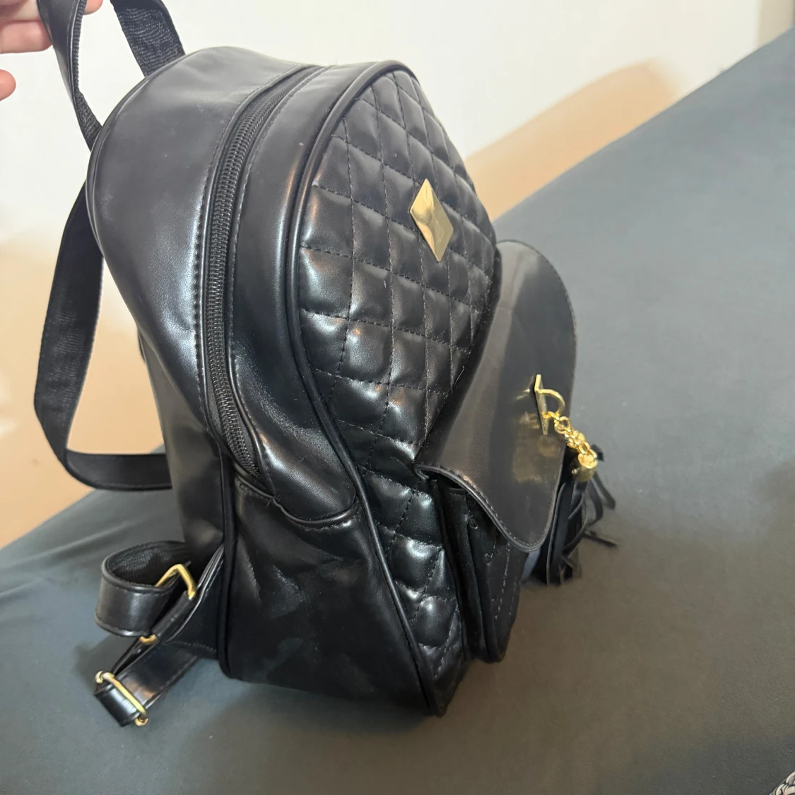 Svart quiltad ryggsäck med fransar