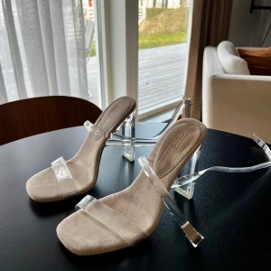 Transparenta klackskor med remmar - Snygga klackskor från Asos med transparenta remmar och klack. Skorna har en öppen tå och en stilren design som passar perfekt för festliga tillfällen och till vardags under ett par jeans!