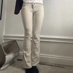 Beige bootcut byxor - Snygga beige bootcut jeans i storlek 12-13 år men skulle säga xxs-xs ungefär. De har ett litet hål men det syns inte så mycket när man har på sig jeansen och går säkert att fixa hos skräddare.
