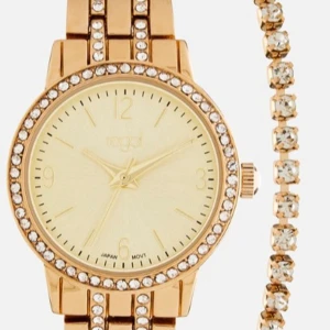 Guldfärgad klocka med strassdetaljer - Elegant guldfärgad klocka från Regal.Perfekt accessoar för att lyfta din stil.