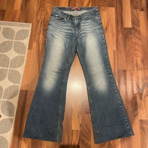 Blå bootcut jeans från Only - Snygga blå bootcut jeans från Only med en klassisk femficksdesign. Jeansen har en lätt tvättad look och är perfekta för en avslappnad stil. De har en normal passform och är tillverkade i slitstarkt denim. UPPSYDDA MED LÅG MIDJA
