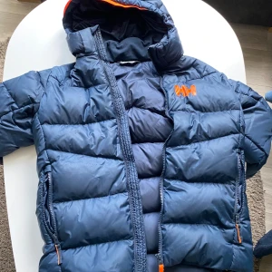 Mörkblå dunjacka från Helly Hansen - Tjenare säljer en mörk blå helly Hansen jacka, perfekt för vintern jätte varm och den funkar som jacka när man åker till fjällen!