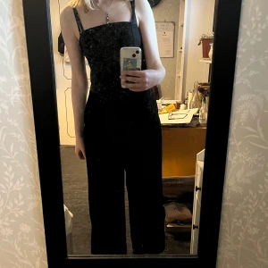 svart jumpsuit - jättefin jumpsuit i tunt och svalt material. den har två fickor. köpt second hand och aldrig använt! jag är 176 så den är lite kort för mig. längd inkl axelband - 139 cm. bredd vid midjan - 34 cm