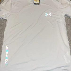 Vit t-shirt från Under Armour - Snygg vit t-shirt från Under Armour. Helt ny med lapp på skriv för fler bilder eller frågor.
