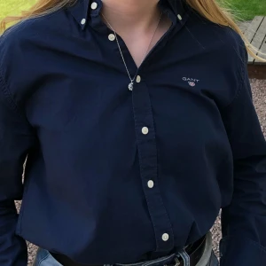 Blå skjorta från GANT stl 170 - Stilren o fin marinblå skjorta från Gant stl 170. Broderad logga på bröstet.  Fint skick.