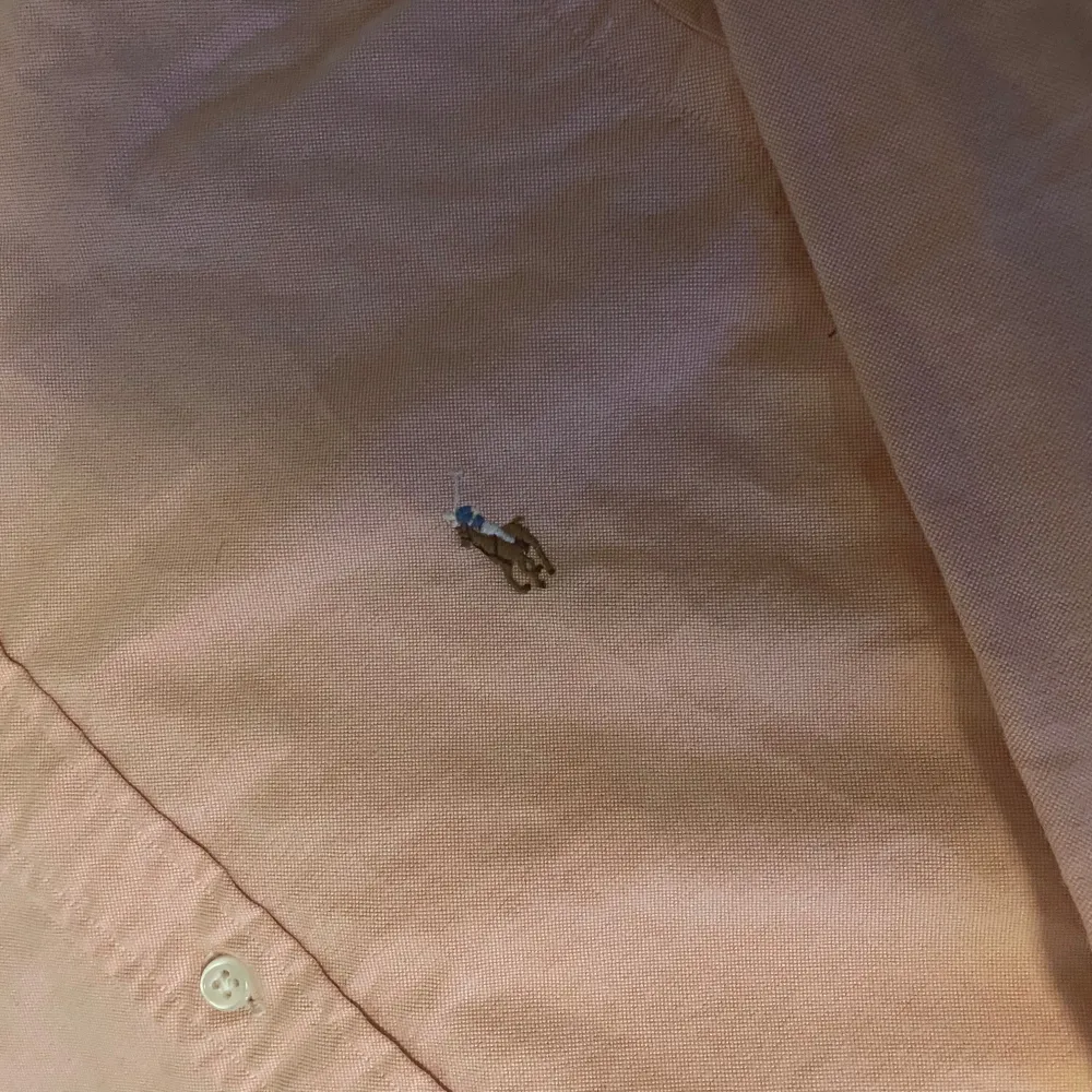 Säljer denna skitfeta aprikosfärgade ralph lauren skjorta! | Skjortan är i storlek S custom fit. | Perfekt för sommaren då den verkligen tar fram solbrännan och automatiskt gör dig brunare. | Dåligt ljus på bilderna men på första ser man hur den ser ut! | Släng iväg en signal vid funderingar så svarar jag snabbt. |. Paidat.