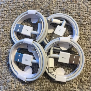Vita USB till Lightning-kablar - Säljer fyra vita USB till Lightning-kablar. Perfekta för att ladda din iPhone eller iPad. Kablarna är snyggt ihoprullade och redo att användas. Passar alla enheter med Lightning-port.