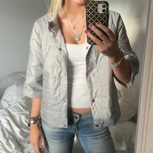 Grå quiltad jacka med 3/4 ärmar - Snygg grå quiltad jacka med trekvartsärm och knappar. Perfekt för en stilren look. Hernoliknande. Storlek S 🩷