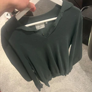 Mörkgrön tröja från Bläck - Säljer en stilren mörkgrön tröja från Bläck i storlek M. Tröjan har en klassisk krage och knappar vid halsen. Perfekt för en avslappnad men ändå snygg look.