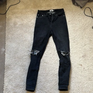 Svarta jeans med slitningar - Snygga svarta jeans från lager 157 med slitningar på knäna. De har en tight passform och är högmidjade.