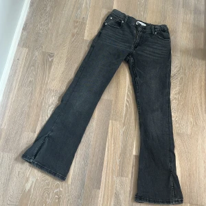 Svarta flare/bootcut jeans med slits från Zara - Snygga svarta jeans från Zara i storlek XS. De har en bootcut-stil med slits vid bensluten och en klassisk femficksdesign. Perfekta för en trendig look! Säljer då de är lite för korta för mig. Storlek 164 men passar om man är kortare, sitter som en xs ungefär. Endast använda fåtal gånger och säljs inte längre på Zaras hemsida.