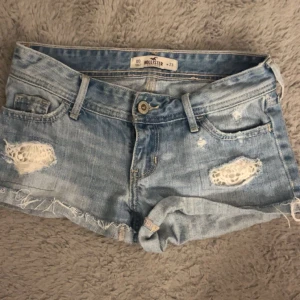 Ljusa jeansshorts från Hollister - Säljer ett par ljusa jeansshorts från Hollister med slitna detaljer och fransar. De har en klassisk femficksdesign och knappgylf. Är as snygga och säljer för att dem är för små, använda fåtal gånger💕går inte att köpa längre