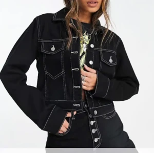 Jeansjacka - En jättesnygg svart jeansjacka med vita sömmar, den är croppad, storlek xs men skulle säga att den passar s med! Mycket använd men har inga defekter alls🖤skriv för fler bilder