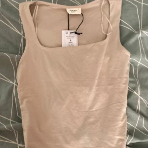 Beige topp från Gina Tricot - Säljer en beige topp från Gina Tricot, helt oanvänd och med tagg. Toppen har en fyrkantig halsringning och passar bra att matcha med både jeans och kjol. Perfekt för de uppkommande sommardagar. Säljer då jag fick två av samma och inte hann returnera. Nypris 160kr. 💞💞