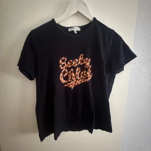 Mörkblå t-shirt från See by Chloé  - Snygg mörkblå t-shirt från See by Chloé med ett coolt mönstrat tryck i orange och vitt på framsidan. Perfekt för en avslappnad stil med en touch av lyx. Nypris 899