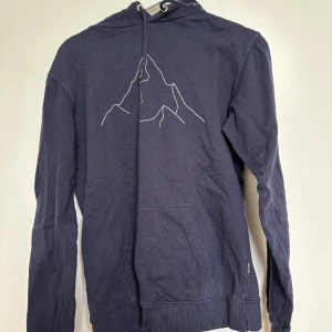 Mörkblå hoodie från Dedicated - Säljer en mörkblå hoodie från Dedicated i storlek S med broderi på framsidan. Endast använd ett fåtal gånger.
