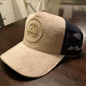Beige/blå keps från AllCapOne - AllCapOne keps i färgen beige/blå. Har använt den en gång så den är i ny skick. Hör gärna av er för fler frågor! 