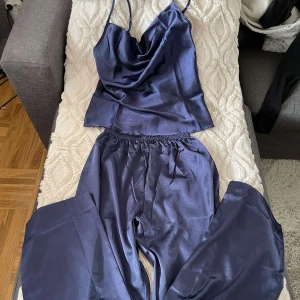 Ett sett i marinblå silke  - Pyjamas sett i marinblått silke. Ett par byxor o ett linne. Sitter väldigt lent mot huden och har väldigt bra skicka, har andvänt kanske 2-3 gånger. 